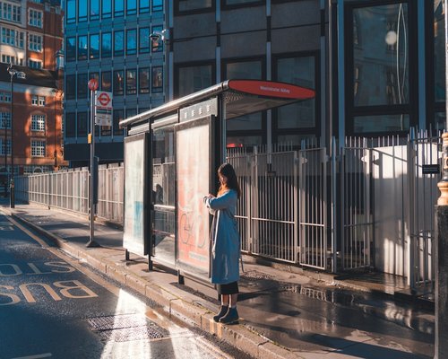 Person waiting calmly at a bus stop in the city
